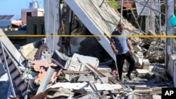 A Lebanese man inspects the ruins of a house that was hit on Friday night by an Israeli airstrike, killing one woman and wounding several other people, in the southern village of Adloun, Lebanon, June 1, 2024.