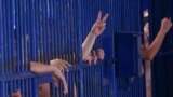 FILE - Detainees flash gestures at a Bangkok immigration detention center in Bangkok, Thailand, Jan. 21, 2019. According to the son of one former detainee, more than 50 adult Uyghur men remain in Thailand's immigration detention facilities. 