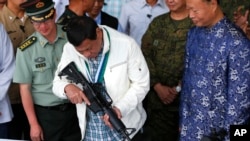 资料照 - 2017年6月28日，中国向菲律宾提供了数以千计的中国造CQA5突击步枪和弹药。彼时的菲律宾总统杜特尔特手里拿着一支CQA5突击步枪，兴致勃勃地把玩着。