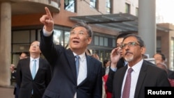 China's Commerce Minister Wang Wentao gestures as South Africa's Minister of Trade Ebrahim Patel shows him the Department of Trade, Industry and Competition's campus, before the start of talks in Pretoria, South Africa, Aug. 10, 2023.