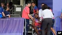 Noah Lyles of the United States is helped off the track after the men's 200-meter final at the 2024 Summer Olympics, Aug. 8, 2024, in Saint-Denis, France. 