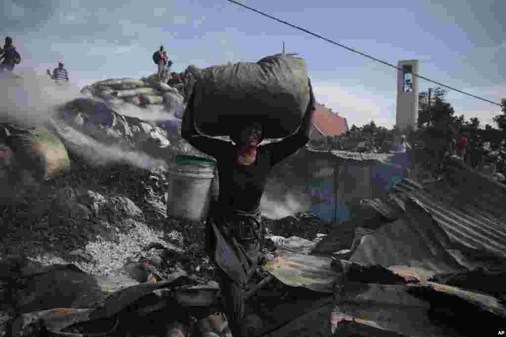 Продавач спасува предмети од изгорените урнатини на пазарот Шада во областа Петион-вил во Порт-о-Пренс, Хаити.