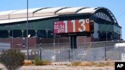 FILE - With Chase Field, home of the Arizona Diamondbacks baseball team in the background, a digital billboard updates the time and temperature as temperatures are expected to hit 116° F in Phoenix, Arizona, July 18, 2023.