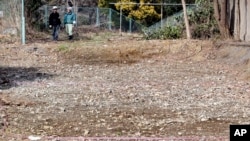 FILE - A pink ribbon is marked on the ground on Feb. 21, 2011, at the site of a former medical school in Tokyo, as Japan began excavating the site of the former school linked to Unit 731, a germ and biological warfare unit during the war.