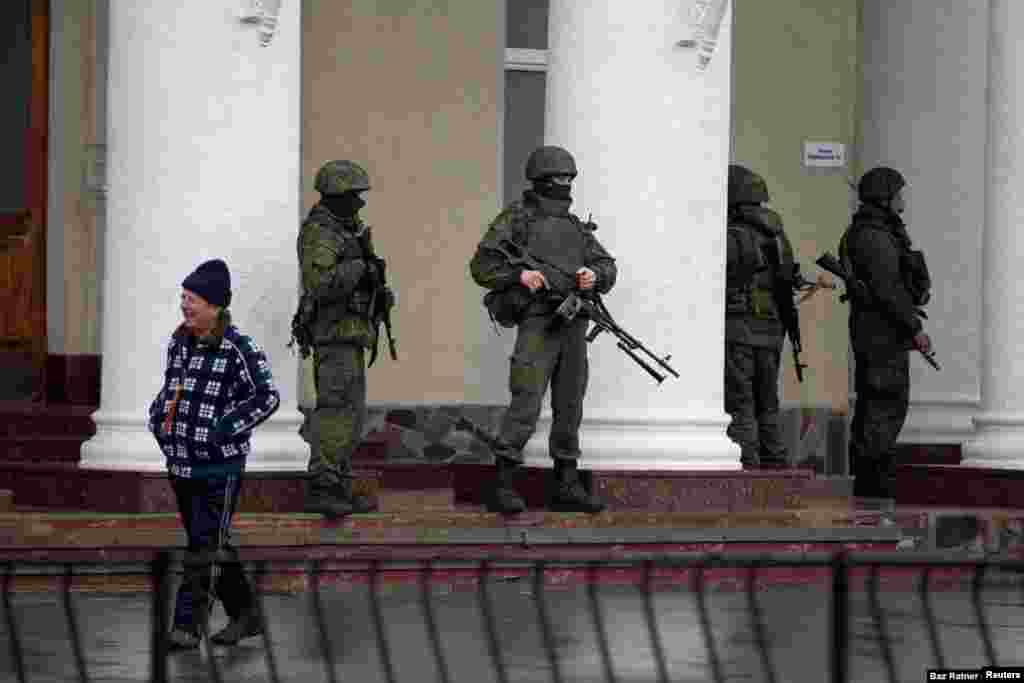 Soldados sin insignias en el exterior del aeropuerto de Simferopol el 28 de febrero. Soldados de incógnito aparecieron por toda Crimea y se les conoció como &ldquo;pequeños hombres verdes&rdquo;. El Kremlin inicialmente afirmó que los soldados eran grupos locales de &ldquo;autodefensa&rdquo;, pero luego admitió que eran soldados rusos profesionales.
