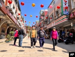 Tourists were seen walking on the street in the shopping district on Nangan, part of Matsu Islands, Taiwan on Tuesday, March 7, 2023. (AP Photo/Johnson Lai)