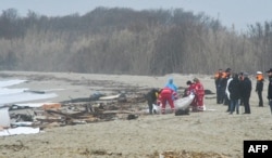Tim penyelamat mengangkat kantong jenazah korban yang terdampar di Steccato, Cutro, selatan Crotone, setelah kapal migran tenggelam di wilayah Calabria selatan Italia, 26 Februari 2023, . (STRINGER / ANSA / AFP)