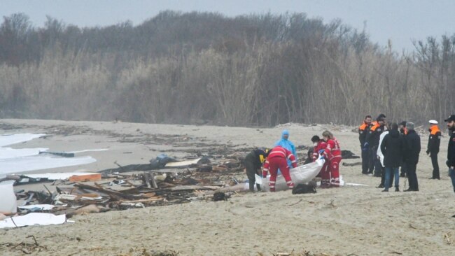 This photo obtained from Italian news agency Ansa, taken on Feb 26, 2023 shows rescuers handling a body bag at the site of a shipwreck in Steccato di Cutro.
