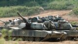 FILE - US M1A1 Abrams tanks block a path at a training range in Paju, near Demilitarized Zone (DMZ), 50 kilometer north of Seoul, on June 9, 2003. 