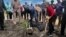 FILE - Rita Joy Samantha Burk (R), assisted by Africano Mande (L) plants a tree on the premises of the South Sudan National Revenue Authority in Juba. VOA/Juliana Siapai