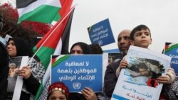 Para demonstran membawa plakat dan bendera Palestina dalam aksi protes di luar kantor UNRWA di Beirut pada 27 Maret 2024, untuk mendukung salah satu staf UNRWA yang diskors. (Foto: Reuters/Mohamed Azakir) 