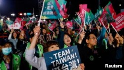 台湾民进党支持者1月13日挥舞“Team Taiwan,挺台湾”的旗帜，等候选举结果的揭晓