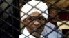 FILE - Sudan's former president Omar Hassan al-Bashir smiles as he is seen inside a cage at the courthouse where he is facing corruption charges, in Khartoum, Sudan August 31, 2019.