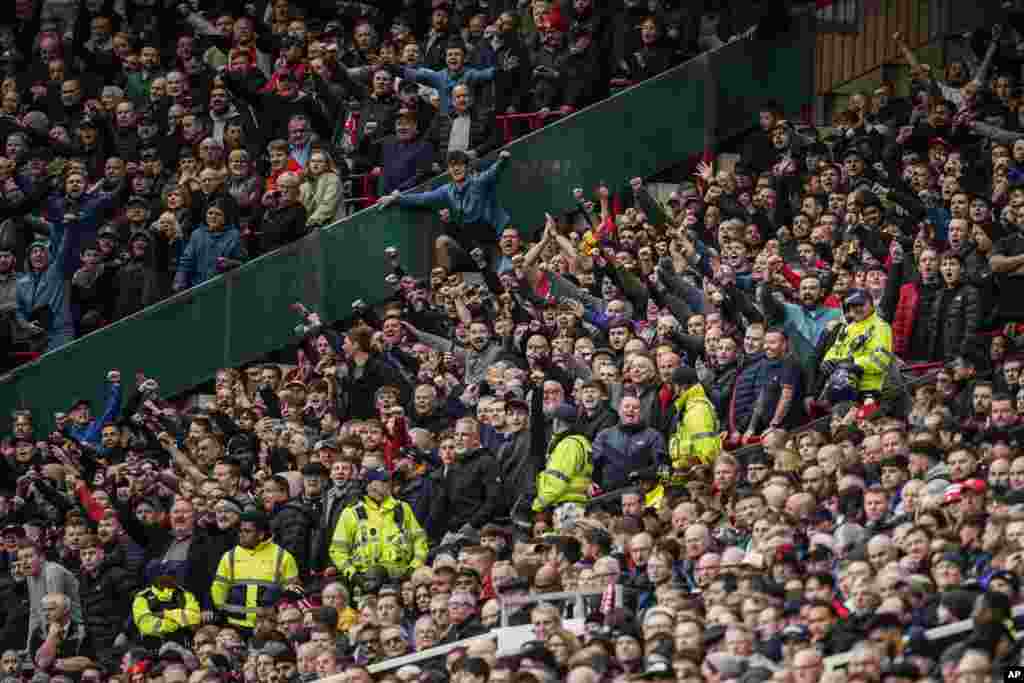 Liverpool&#39;s fans, top, celebrate as Luis Diaz scored the opening goal during the English Premier League soccer match between Manchester United and Liverpool at the Old Trafford stadium in Manchester, England.