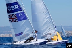 Michael Beckett of Britain and Pavlos Kontides of Cyprus round a mark during an ILCA 7 dinghy class practice race at the 2024 Summer Olympics on July 27, 2024, in Marseille, France.