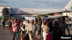 People evacuated from Israel on a Bulgarian government plane react after arriving at Sofia International Airport, in Sofia, Bulgaria, Oct. 8, 2023. 