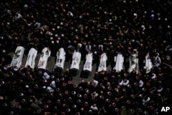 Mourners from the Druze minority surround the bodies of some of the 12 children and teens killed in a rocket strike at a soccer field, in the village of Majdal Shams at the Israeli-controlled Golan Heights, July 28, 2024.