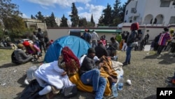 Des migrants subsahariens campent devant l'ambassade de Côte d'Ivoire à Tunis le 28 février 2023.