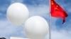 抗议者在中国驻华盛顿大使馆外释放的白色气球在中国国旗旁漂浮。（2023年2月15日）