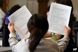 Jenes Ochoa Rojas goes over the lines of a three-scene play written by ChatGPT in Donnie Piercey's class at Stonewall Elementary in Lexington, Ky., Monday, Feb. 6, 2023. (AP Photo/Timothy D. Easley)