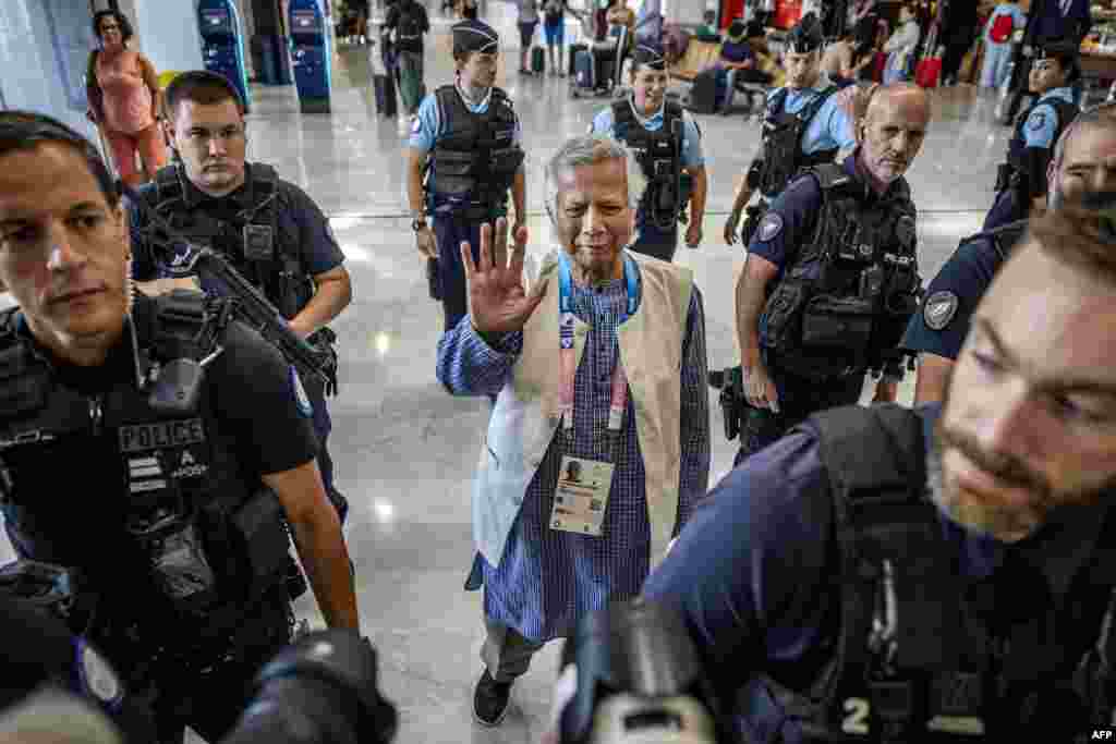 Bangladesh&#39;s finance pioneer Muhammad Yunus (C) is escorted by French police personnel as he arrives at Roissy-Charles de Gaulle Airport, north of Paris, enroute to Bangladesh, where he is set to lead a caretaker government after mass protests ousted premier Sheikh Hasina.