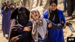 A woman is helped as she reacts to the death of relatives in an earthquake in the mountain village of Tafeghaghte, southwest of Marrakesh, Sept. 10, 2023.