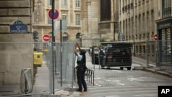 A police officer attaches fences at the security perimeter at the 2024 Summer Olympics, in Paris, France, July 21, 2024.