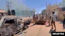 RSF fighters stand near the damaged Air Defence Forces command centre in Khartoum, Sudan May 17, 2023, in this screen grab obtained from a social media video.