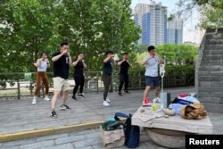 资料照：北京街头几人在直播健身锻炼。（2022年5月1日）