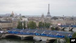 FILE - Police boats patrol the Seine river in Paris, France, ahead of the opening ceremony of the 2024 Summer Olympics, July 26, 2024. 