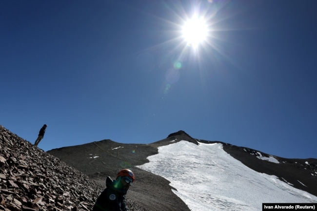 Mountain guides Luis Diaz and Daniela Pagli take a break next to Iver glacier close to the El Plomo mountain summit, in the Andes mountain range, in the Santiago Metropolitan Region, Chile, April 4, 2024. (REUTERS/Ivan Alvarado)