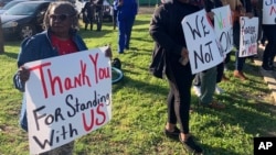 FILE - Glenda Austin of Idabel, Oklahoma, holds a sign with other protesters on April 17, 2023, outside the McCurtain County Commissioners meeting room in Idabel, Oklahoma. 