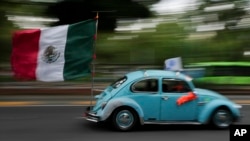 An antique Volkswagen Beetle, known in Mexico as a "vocho," parades through the streets a day after World Vocho Day, in Mexico City, June 23, 2024.