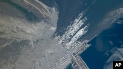 This satellite image provided by Planet Labs PBC shows an overview of the damage at the Kakhovka dam in southern Ukraine, June 6, 2023. (Planet Labs PBC via AP)