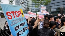 Protesters stand outside the Japanese Embassy in Seoul, South Korea, to denounce the release of treated radioactive water into the sea from the damaged Fukushima nuclear power plant, Aug. 24, 2023.