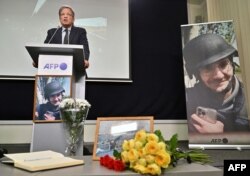 FILE - Chairman and Chief executive officer of Agence France-Presse, Fabrice Fries, speaks next to a portrait of AFP journalist Arman Soldin, who was killed in the Donbas region while covering the conflict in Ukraine, during commemoration ceremony in Kyiv, May 15, 2023.