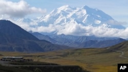 Para wisatawan mengamati Denali, puncak gunung tertinggi di Amerika Utara, di Taman Nasional Denali, Alaska, 26 Agustus 2016. Seorang pendaki Malaysia meninggal dekat puncak Denali setelah terjebak salju, 1 Juni 2024. (Foto: Becky Bohrer/AP Photo)