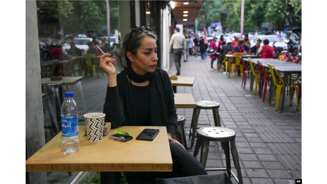A woman sits in the alfresco dining area of a cafe at Tajrish commercial district without wearing her mandatory Islamic headscarf in northern Tehran, Iran, April 29, 2023.