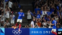 France's Alexandre Lacazette, left, celebrates after scoring his side's first goal during the men's Group A soccer match between France and the United States at the Velodrome stadium, July 24, 2024, in Marseille, France.