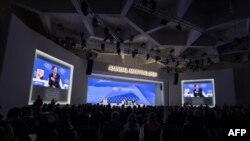 Israeli President Isaac Herzog speaks next to a photograph of 10-month-old baby Kfir Bibas held by Hamas during a session of the World Economic Forum (WEF) meeting in Davos on January 18, 2024.