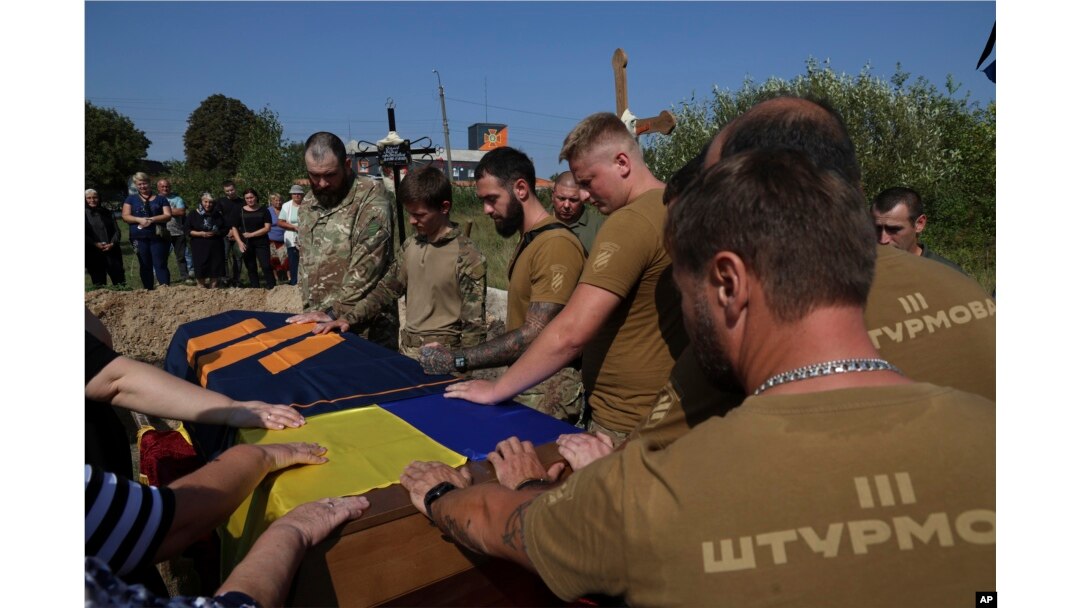Ukrajinski vojnici iz 3. jurišne brigade pozdravljaju poslednji put svog poginulog druga Vadima "Gagarina" Belova, tokom sahrane na groblju u Polonu, oblast Hmeljnicki, u Ukrajini, 13. septembra 2023. Vadin je ubijen tokom jurišne misije kod Bahmuta.