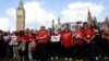 FILE - People gather in Westminster on May 19, 2024, to remember those who lost their lives in the U.K.'s decades-long infected blood scandal. Britain's government said Tuesday the victims of the scandal will start receiving final compensation payments this year.  