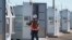 FILE - A worker walks at Orsted's Eleven Mile Solar Center lithium-ion battery storage energy facility, Feb. 29, 2024, in Coolidge, Ariz. Batteries allow renewables to replace fossil fuels while keeping a flow of power when wind or solar are not producing. 