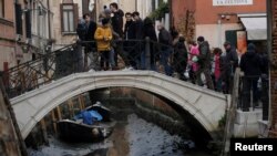 Gondole u kanalu tokom jake oseke u Veneciji, Italija, februar 2023.. 