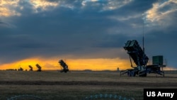 Patriot missile batteries from the US Army's 5th Battalion, 7th Air Defense Artillery Regiment, stand ready at sunset in Poland on April 10, 2022.