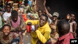 People dance and chant songs in support of the Rwandan Patriotic Front (RPF) and the incumbent President of Rwanda Paul Kagame following the release of provisional electoral results, at a market in Kigali, July 16, 2024.