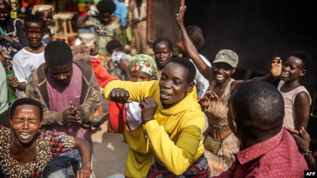 People dance and chant songs in support of the Rwandan Patriotic Front (RPF) and the incumbent President of Rwanda Paul Kagame following the release of provisional electoral results, at a market in Kigali, July 16, 2024.