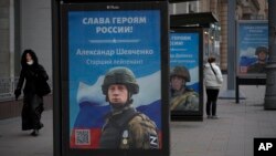 FILE - A billboard shows a picture of a Russian soldier awarded with a medal for his actions in Ukraine, in Moscow, Russia, Nov. 15, 2022.