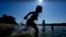 Judah Boyle, of Des Moines, Iowa, splashes water as he runs on the beach at Gray's Lake Park, Aug. 26, 2024, in Des Moines, Iowa. 
