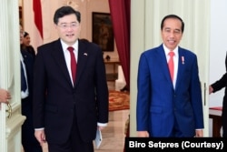 Presiden Joko Widodo berjalan bersama Menteri Luar Negeri China Qin Gang saat bertemu di istana di Jakarta, 22 Februari 2023. (Foto: Biro Setpres RI via REUTERS)